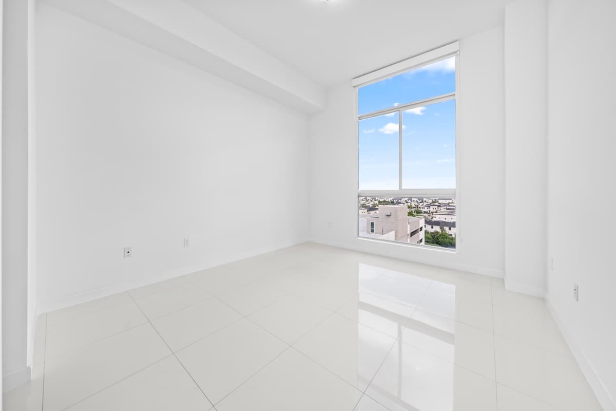 Ljust tomt rum med stora fönster och rena golv inför inflytt eller överlämning.